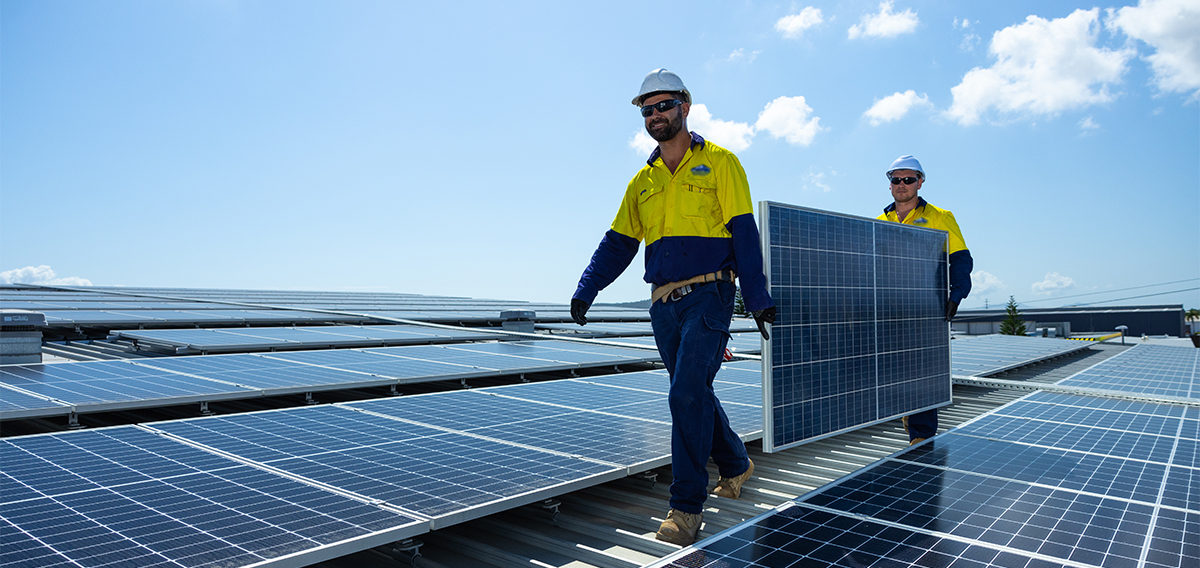 workers with solar panels on a roof